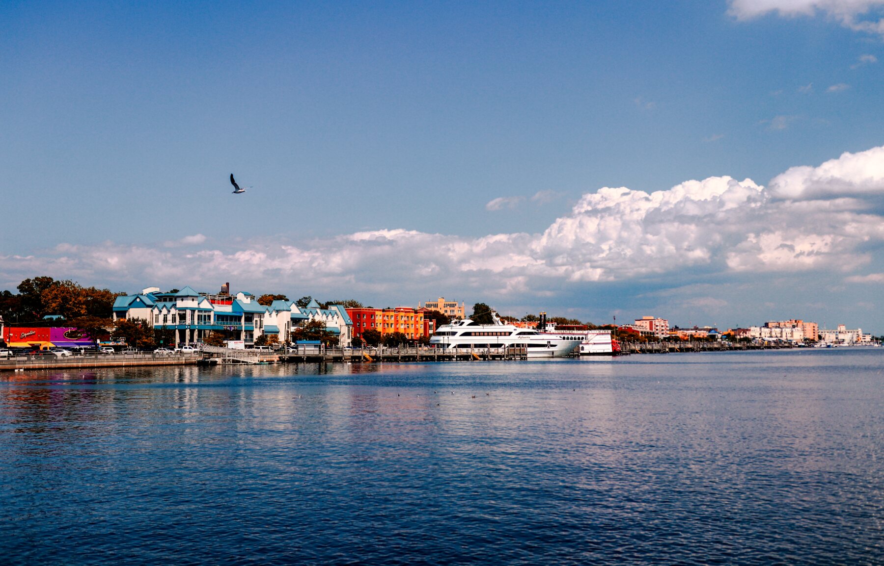 Waterfront town seen across the bay under a blue sky