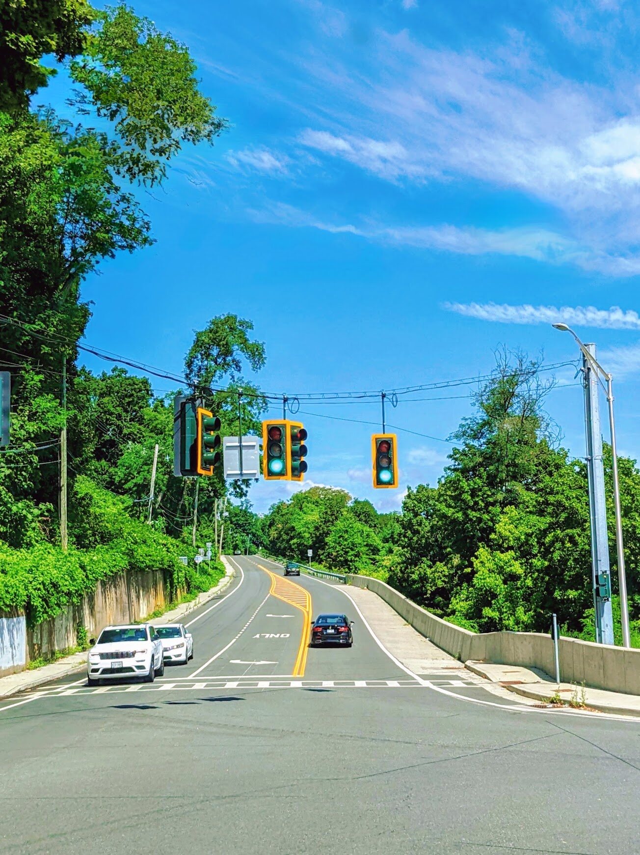 Suburban street lined with trees leading to an intersection
