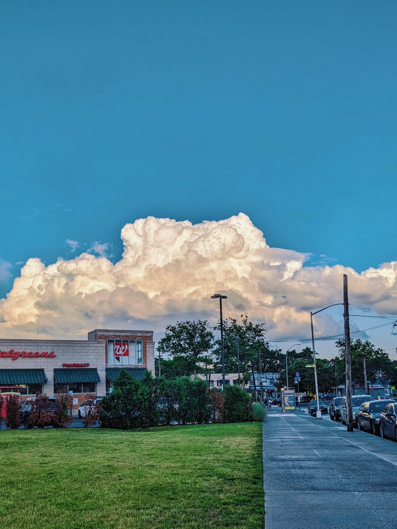 Suburban street corner under a large cloud