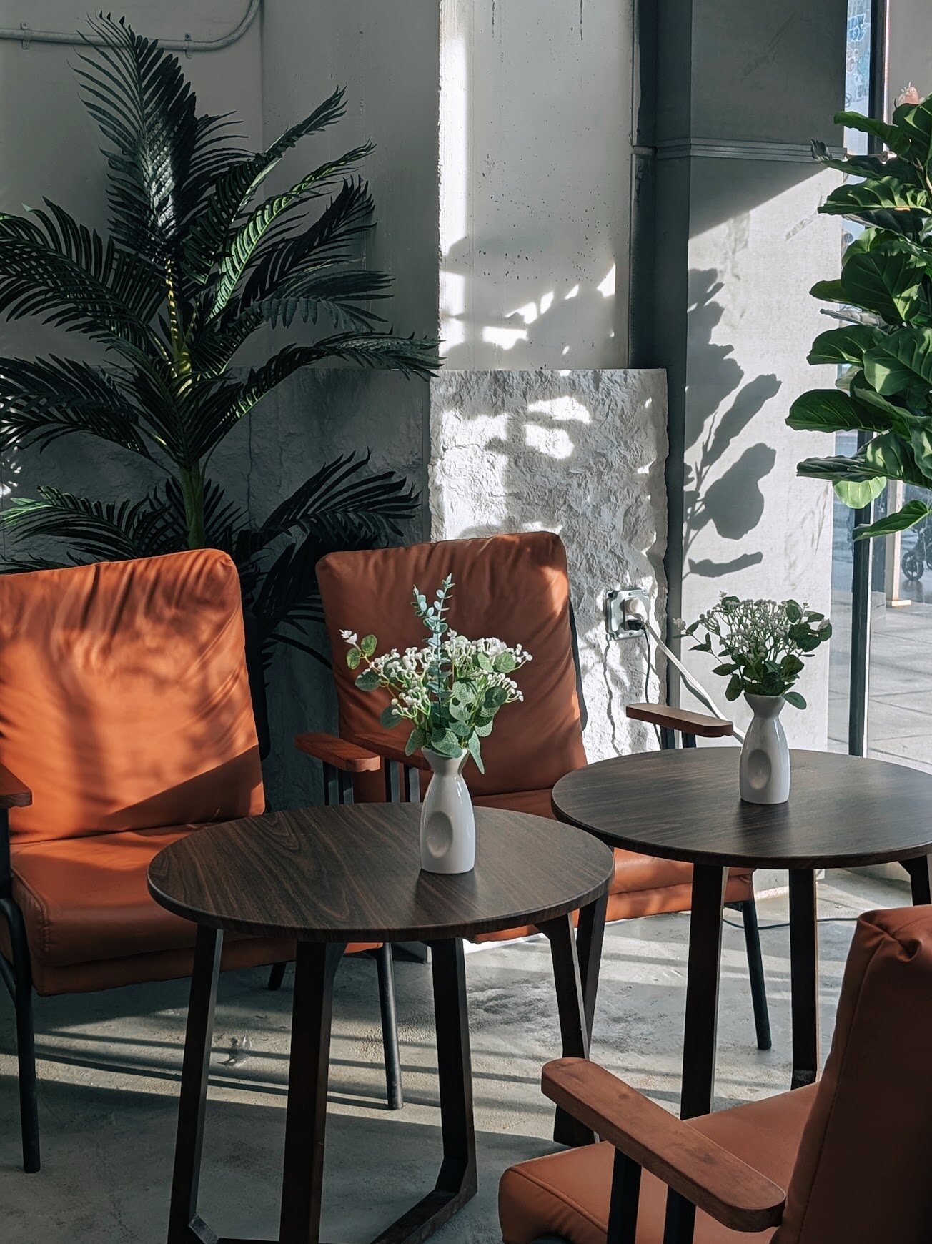 Quiet cafe corner with empty chairs and a small vase of flowers