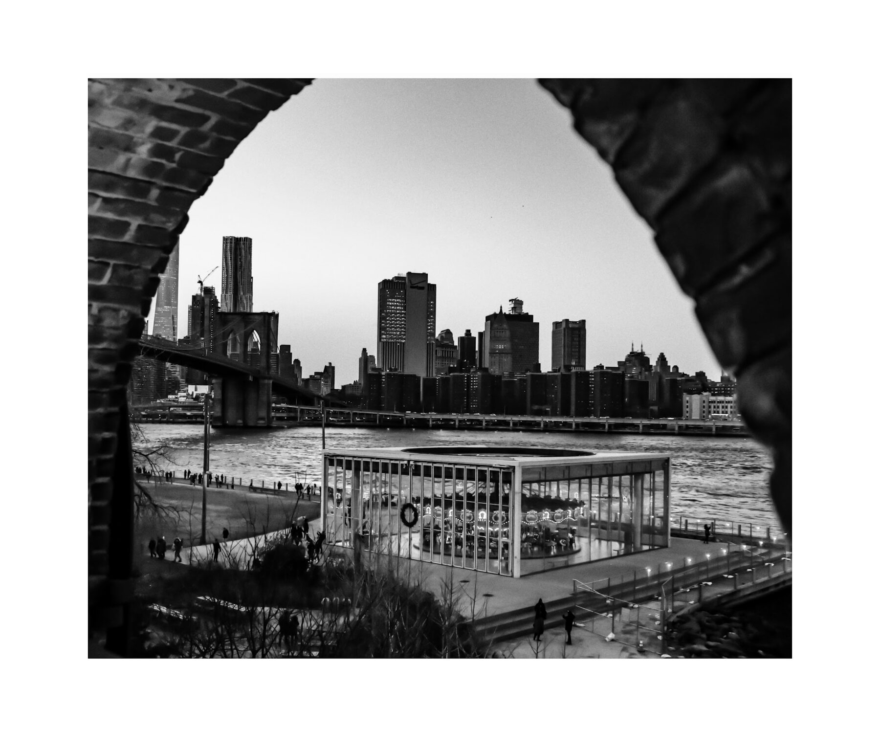 Black and white view of the New York City skyline through a stone archway