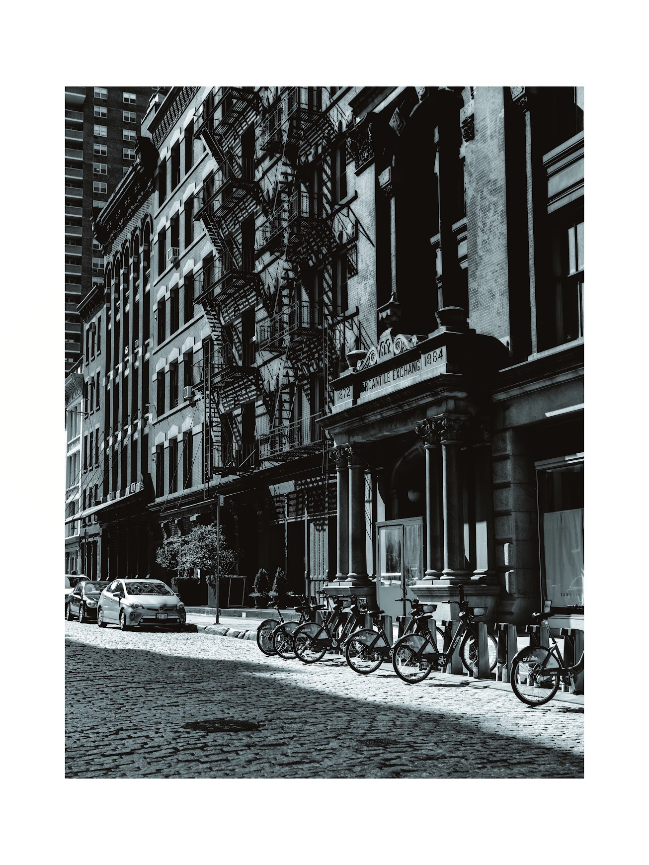 Black and white brownstone street lined with parked bikes