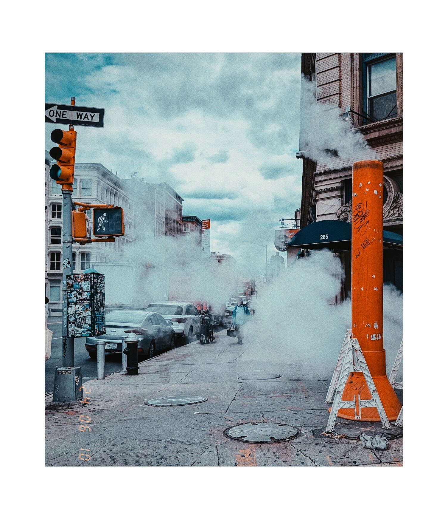 Moody street corner with steam rising from a vent