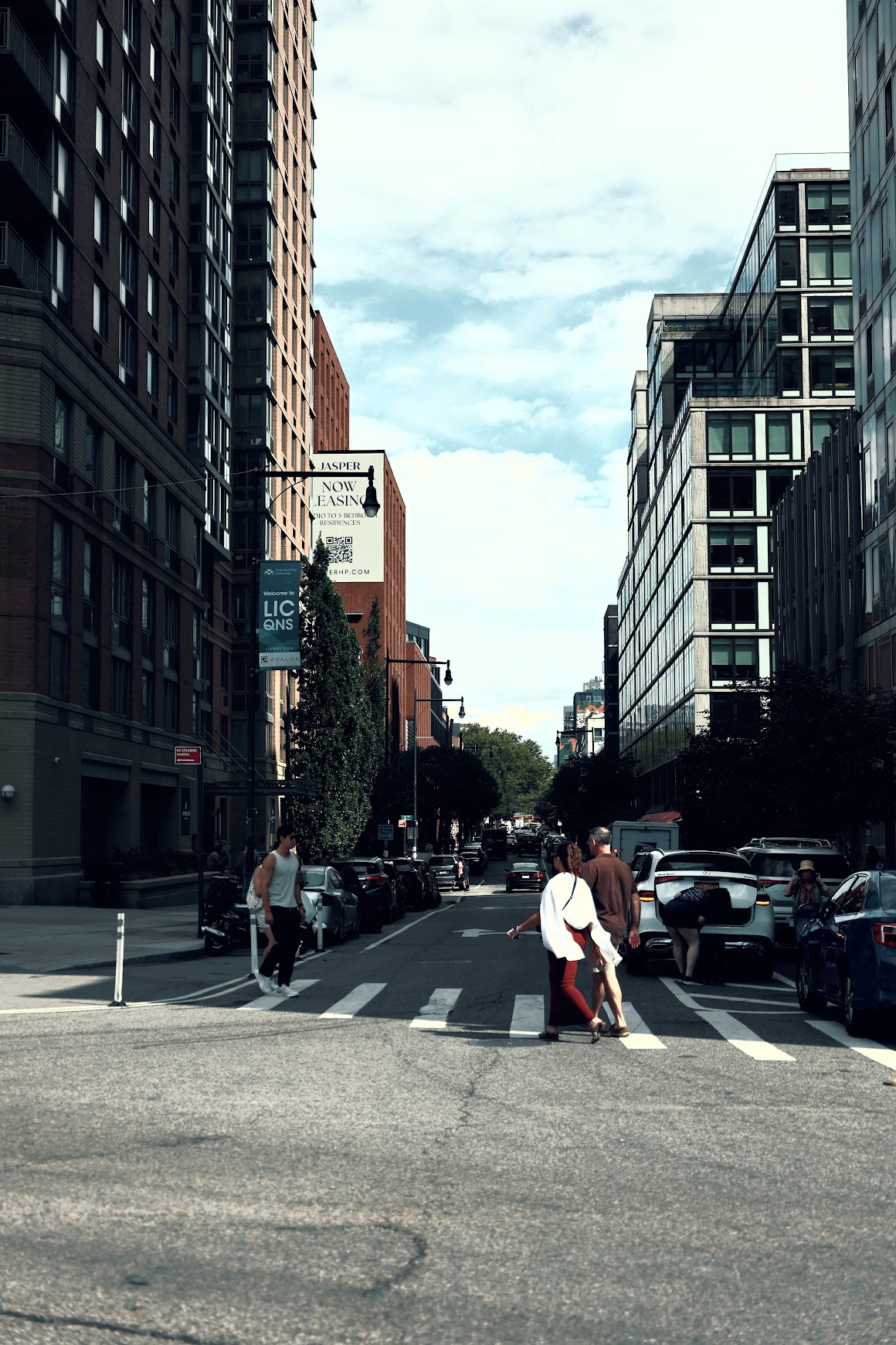 Street crossing in Long Island City lined with tall apartment buildings